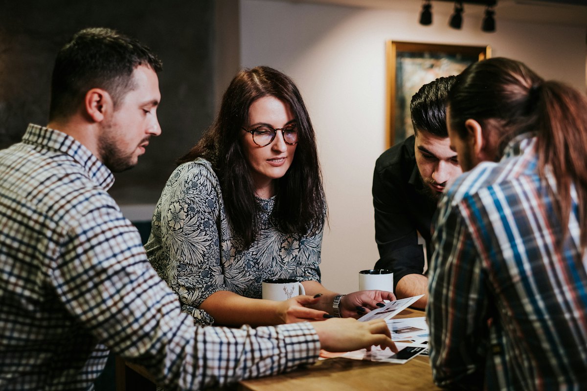 Grupo revisando documentos financeiros em uma mesa de reunião